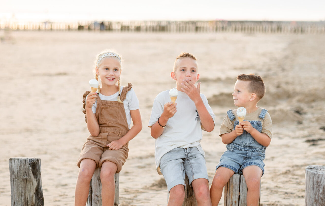 Kinderen eten ijs op het strand