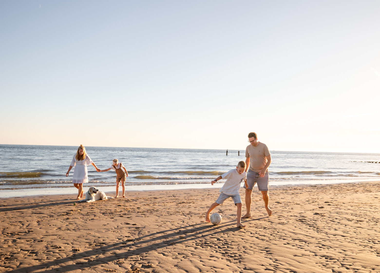 Gezin speelt op het strand van Zeeland