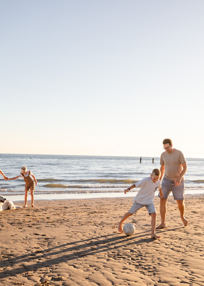 Gezin speelt op het strand van Zeeland