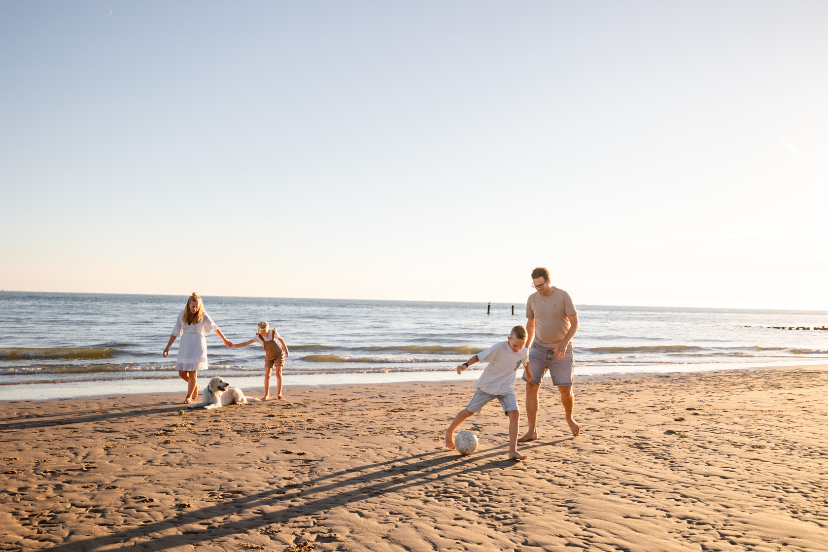 Gezin speelt op het strand van Zeeland