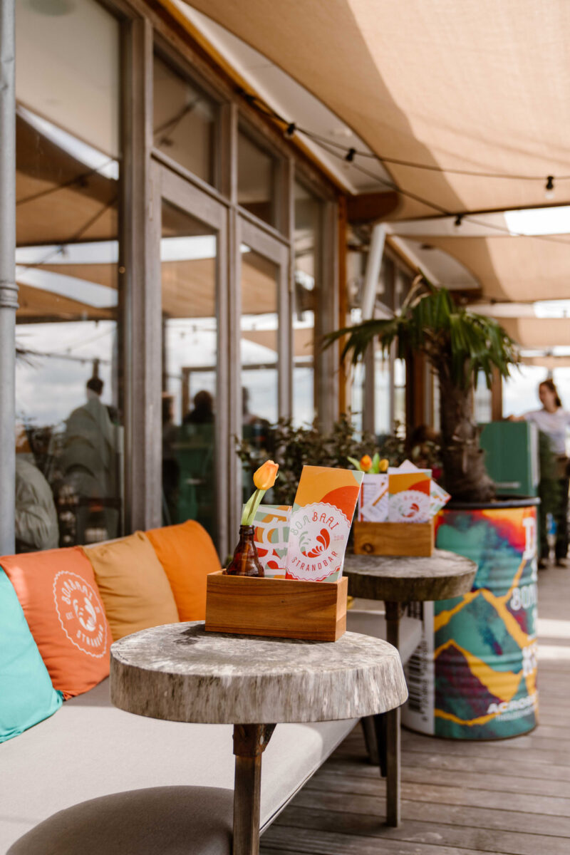 Buiten terras van Bombaai Strandbar met kleurrijke stoelen kussentjes