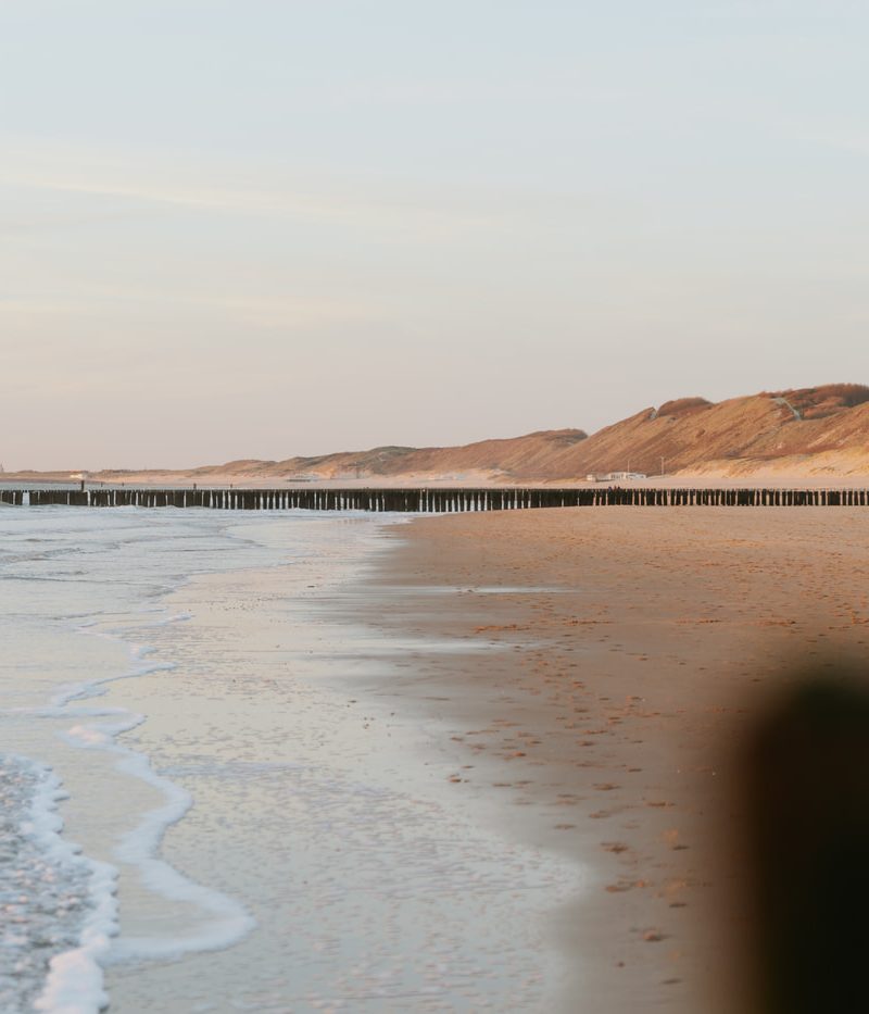 De zee, duinen en strand van Klein Valkenisse bij zonsondergang