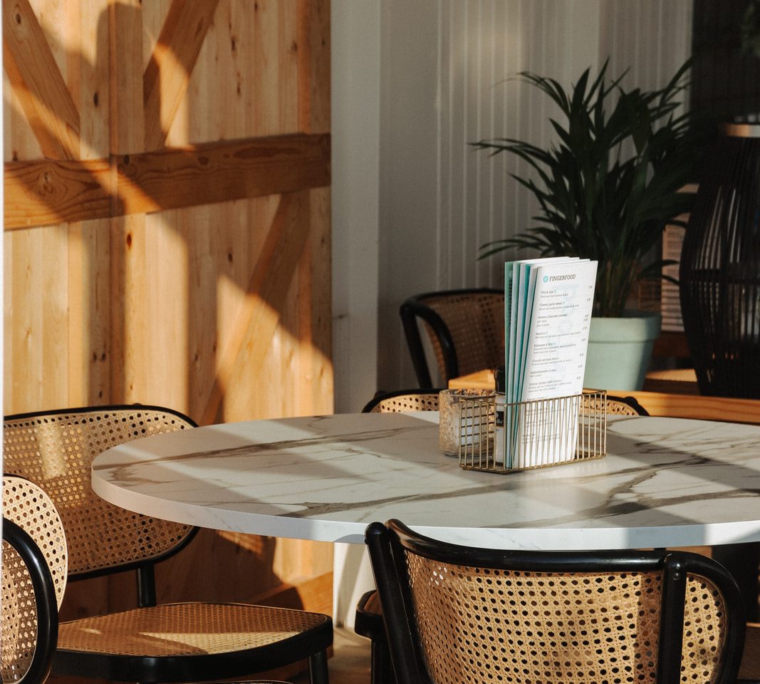Marmeren tafel en rotan stoelen bij Strandpaviljoen Piet Hein