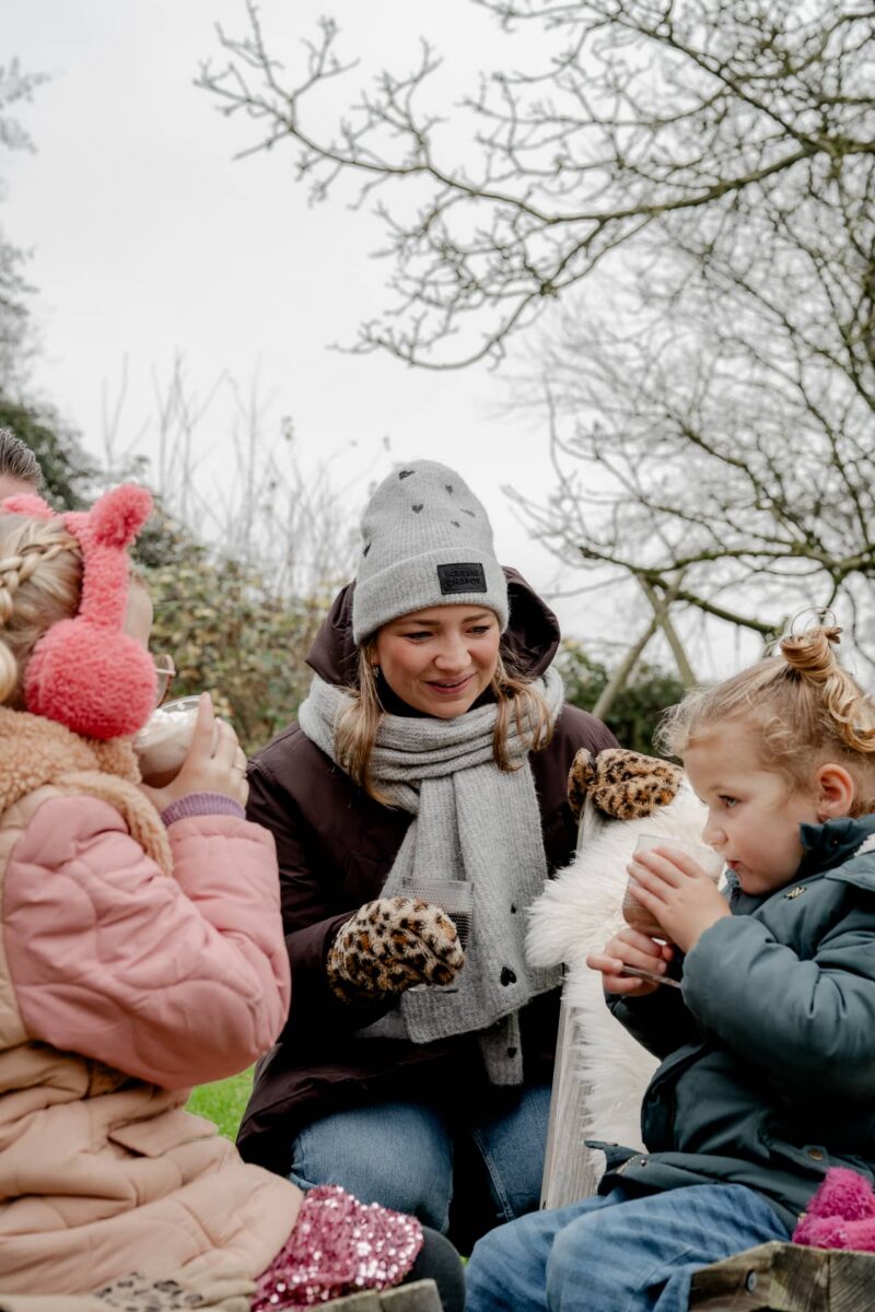 Mama met twee dochters buiten in de winkel