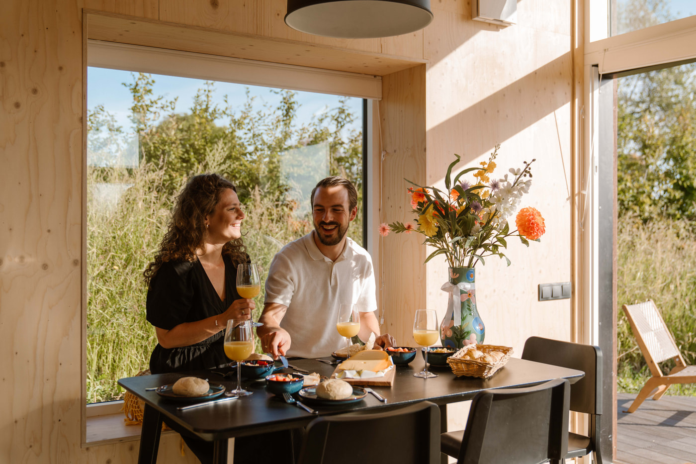 Koppel in Tiny House 16 op Buitenplaats Zeeuwse Liefde in Westkapelle aan de eettafel
