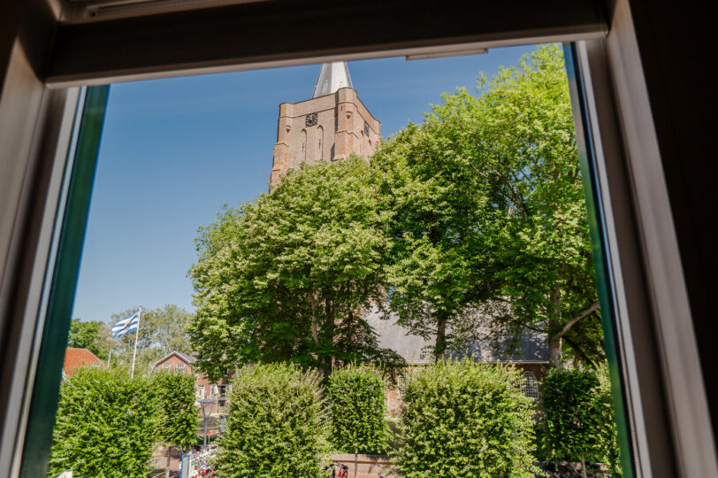 Uitzicht op de kerk vanuit appartement Boven de Babbelaar 2